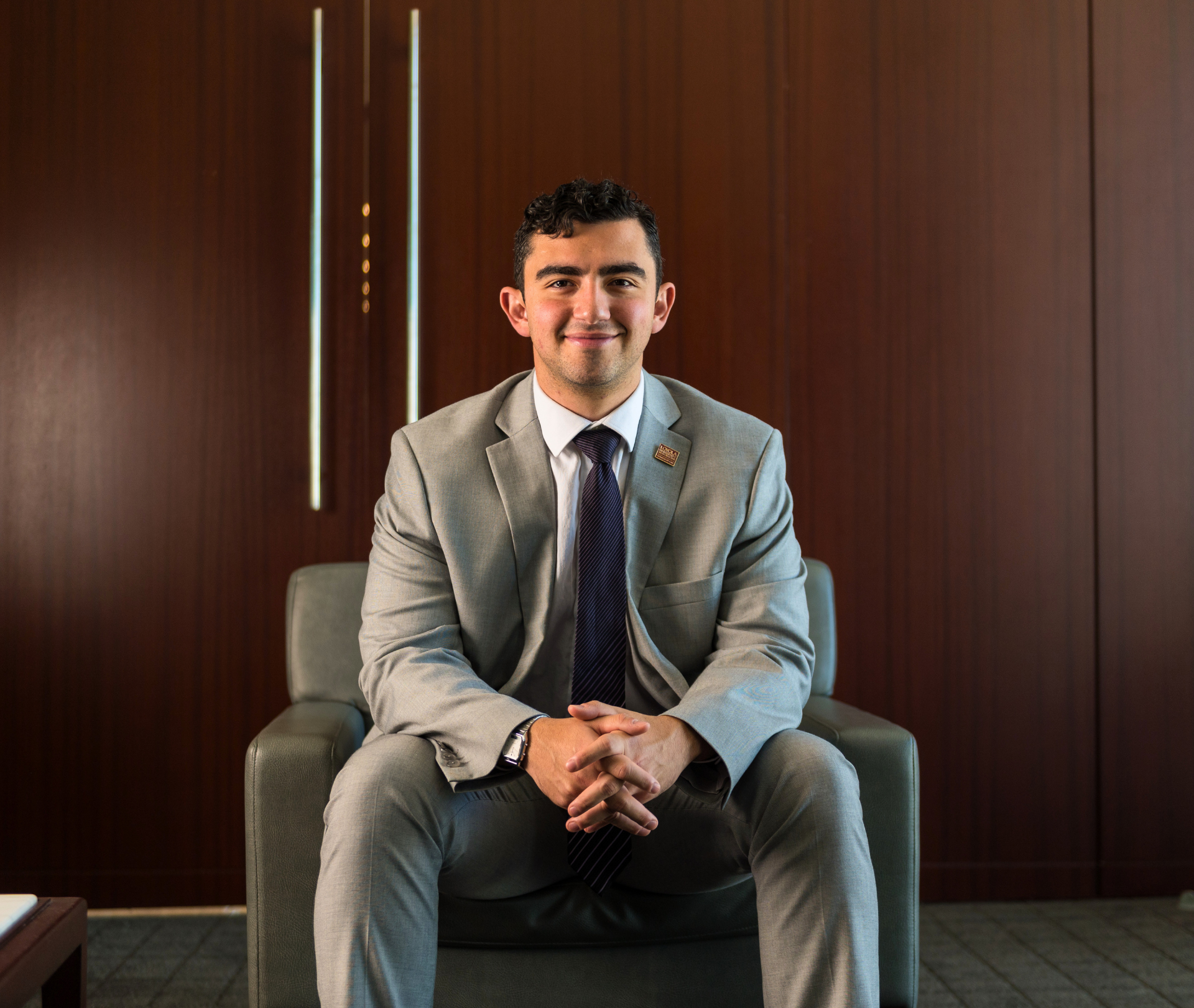 Man in business clothes sitting and smiling.