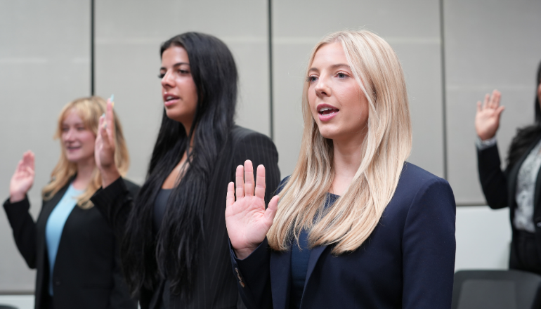 Students raise their hands to be sworn into the law clinic.